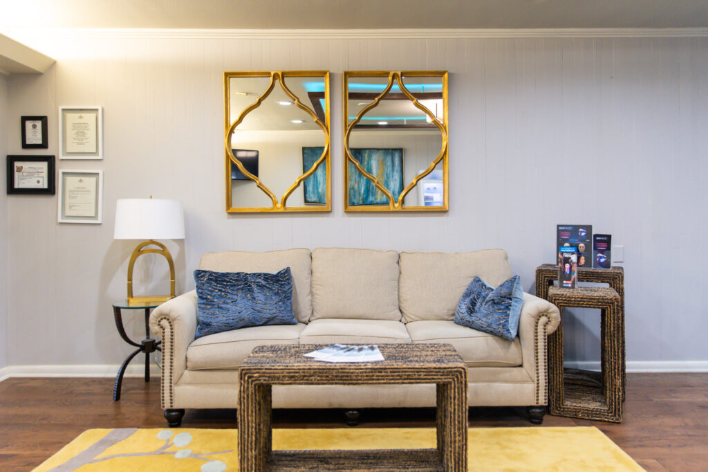 Image of a couch, coffee table, and accent pieces in the waiting area of ReNew Integrated Medical Spa in Texarkana